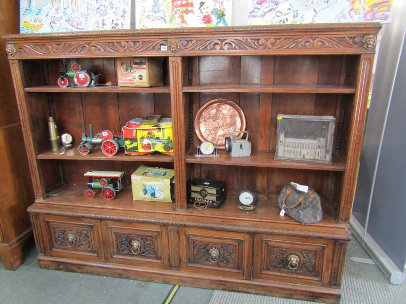 FLEMISH OAK OPEN FRONTED TWIN SECTION BOOKCASE, 4 cupboard base, embellished with copper lionmask