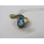 9ct YELLOW GOLD BLUE TOPAZ & DIAMOND BYPASS RING, principal oval cut blue topaz with accent diamonds