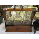 EDWARDIAN TANTALUS, triple decanter tantalus with plated mounts and key, 13" width