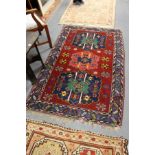 A Persian rug, crimson ground with three central large medallions.