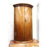 A mahogany bow front hanging corner cupboard.