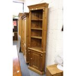 A pine corner unit with shelves above a cupboard door.