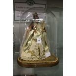 A wax model of the Madonna and Child under a glass dome.