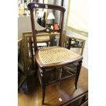 A Victorian cane seated chair and a gilt framed dressing table mirror.