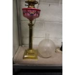 A good brass Corinthian column oil lamp with painted porcelain reservoir.