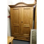 A continental pine two-door armoire with a drawer to the base.