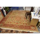 A large Persian style rug, beige ground with broad floral decoration.
