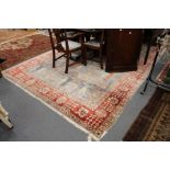 A large modern Persian style carpet, pale blue ground with stylized decoration.