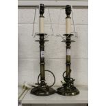 A pair of metal candlestick form lamp bases.