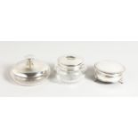 A circular silver jewellery box and two silver mounted cut glass dressing table items.