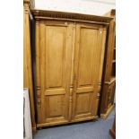 A continental pine two-door armoire.