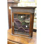 A small mahogany hanging corner cupboard.