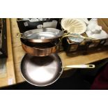 Two good quality copper and brass frying pans and a similar twin handled dish.