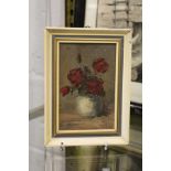 A small oil painting of roses in a vase.