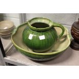 An Arts and Crafts green glazed pottery jug and bowl set (chipped).