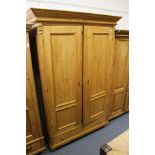 A continental pine two-door armoire with a drawer to the base.