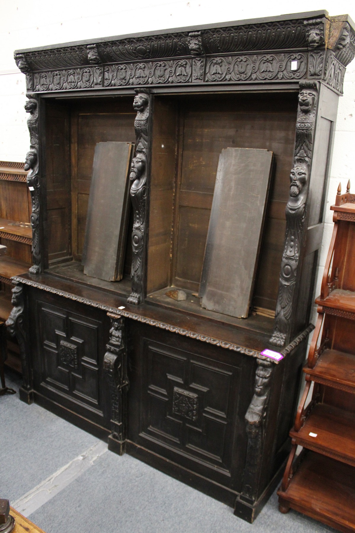 A late Victorian Gothic Revival carved oak cupboard bookcase.