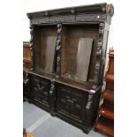 A late Victorian Gothic Revival carved oak cupboard bookcase.