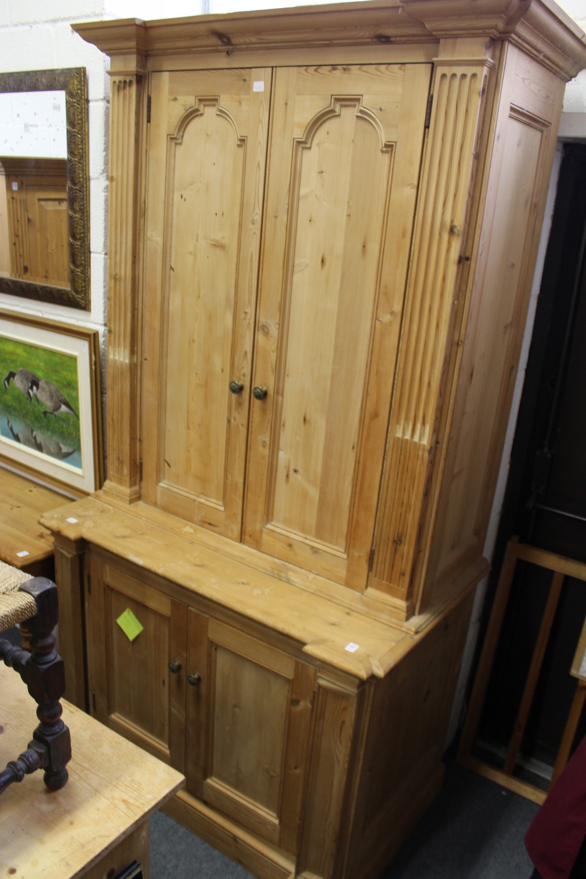 A large pine four-door cupboard fitted for a television etc.