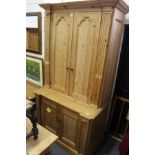 A large pine four-door cupboard fitted for a television etc.