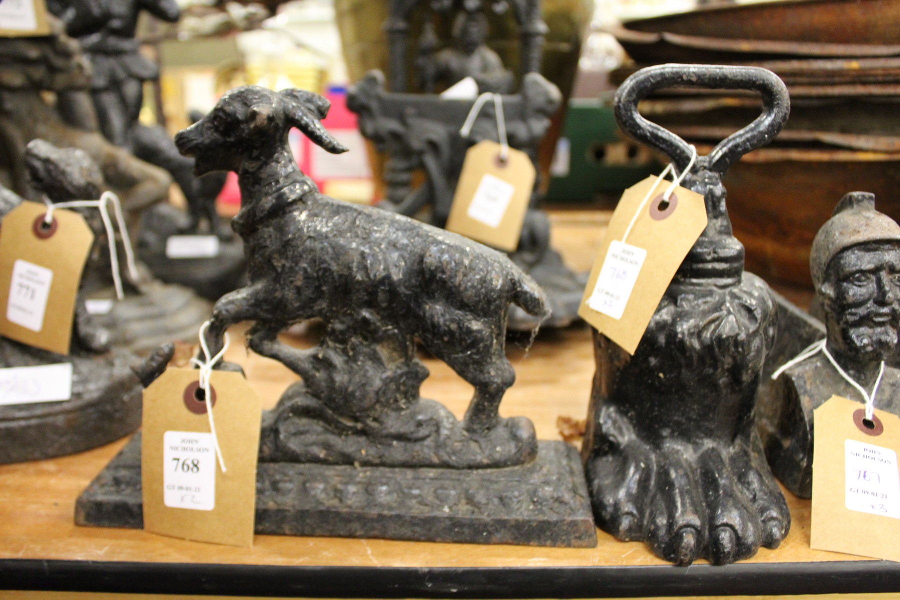 Two cast iron door stops, one modelled as a goat, the other a claw foot.