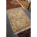 A Persian rug, beige ground with five rows of seven square shaped decorative panels.
