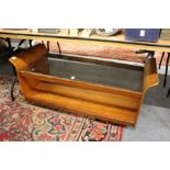 A stylish teak two tier coffee table with curving ends and glass top.