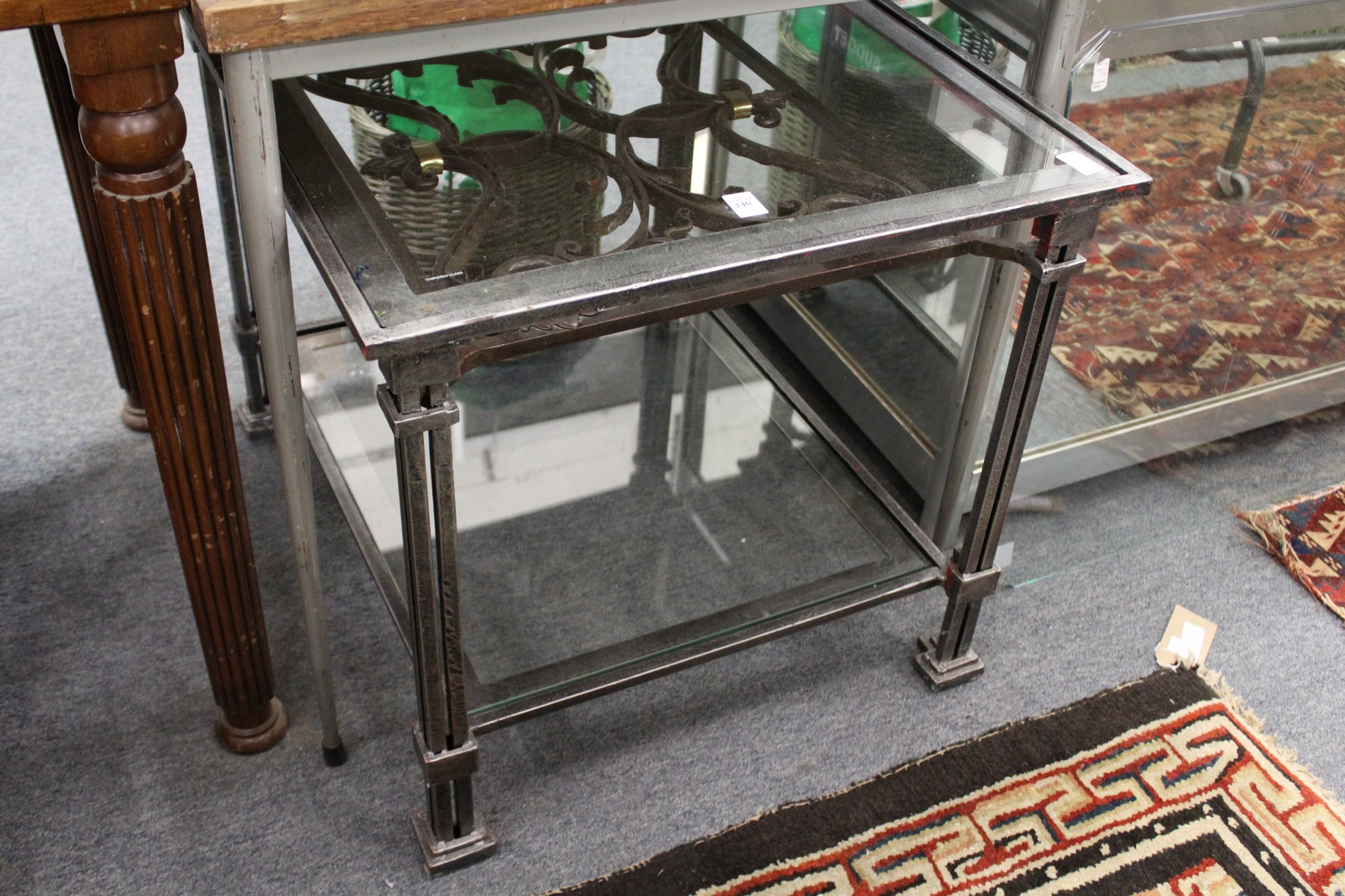 An ornate wrought iron and glass two tier coffee table.