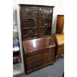 A George III mahogany bureau with associated bookcase top.