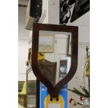 A mahogany shield shaped wall mirror.
