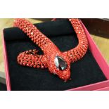 A decorative red stone snake necklace.