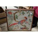 An embroidered picture of an exotic bird.