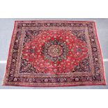 A large Persian design red ground floral decorated carpet.