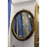 A decorative oval wall mirror.
