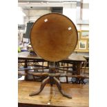 A mahogany circular tilt top tripod table.