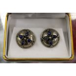 A pair of shield shaped ear studs.