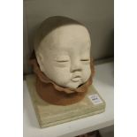 An unusual pottery sculpture of a baby's head.