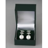 A PAIR OF CHANEL DESIGN SILVER AND PEARL DOUBLE C EARRINGS.