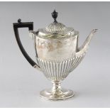 A MATCHING OVAL HALF FLUTED COFFEE POT with ebony handle. London 1893. Weight 19ozs.