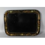 A VICTORIAN RECTANGULAR TOLEWARE TRAY, gilt decorated border, painted with flowers. 26ins wide.