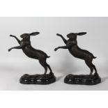 A GOOD PAIR OF BRONZE BOXING HARES on a shaped marble base. 11ins high.