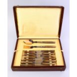 A GOOD BOXED CARVED RHINO HORN HANDLED CUTLERY 29 PIECE SERVICE, in line sectioned box.