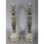 A PAIR OF PLATED AND ROCK CRYSTAL EGYPTIAN FIGURAL CANDLESTICKS on circular bases.