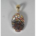 A SILVER ABSTRACT OVAL PENDANT shaped as a turtle.