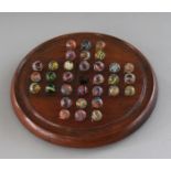 A SMALL SOLITAIRE BOARD, 8ins diameter, and marbles.
