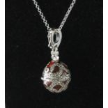 A SILVER AND ENAMEL MARCASITE EGG LOCKET on a chain.