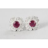 A PAIR OF 18CT WHITE GOLD VINTAGE FLOWER SHAPED RUBY (0.62cts) AND DIAMOND (0.14cts) EARRINGS.