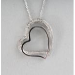 A 9CT GOLD DIAMOND SET HEART PENDANT on a chain.