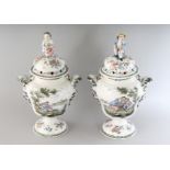 A GOOD PAIR OF FAIENCE VASES AND COVERS painted with figures, scrolls and flowers, the lids with a