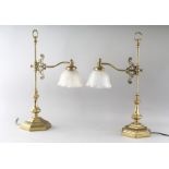 A GOOD PAIR OF HEAVY BRASS DESK LAMPS with glass shades on heavy brass bases. 24ins high.
